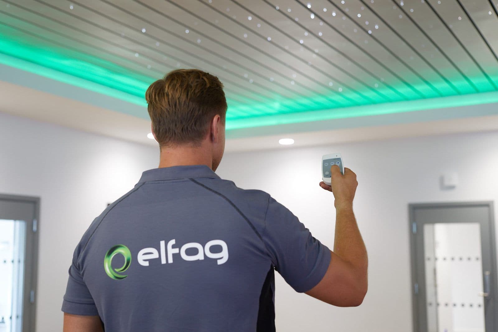 Elektriker justerer lysstyringen i et næringsbygg med indirekte LED-belysning i taket